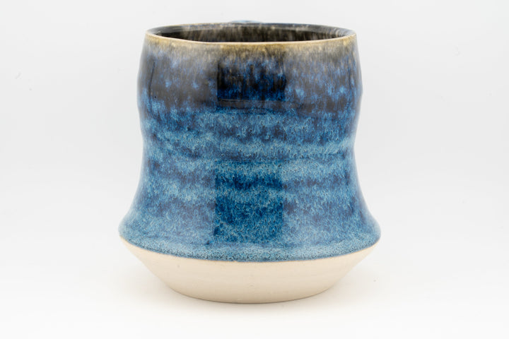 Blue speckled tall ceramic mug, front view with handle cutout visible on side