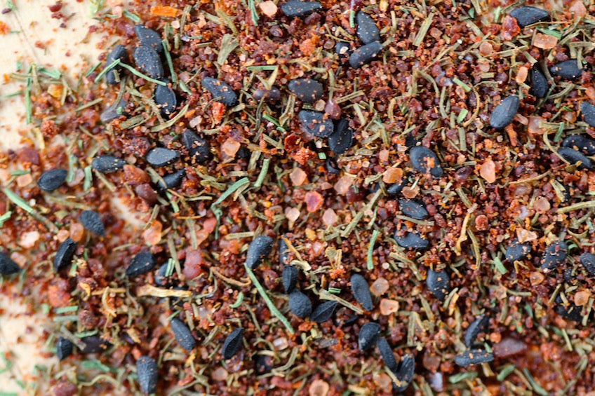 Fish seasoning rub blend with dried herbs and spices, dark blue and green flecks.