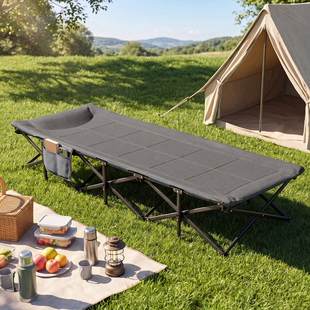 Gray folding camping cot with padded headrest and side storage pouch, on metal legs