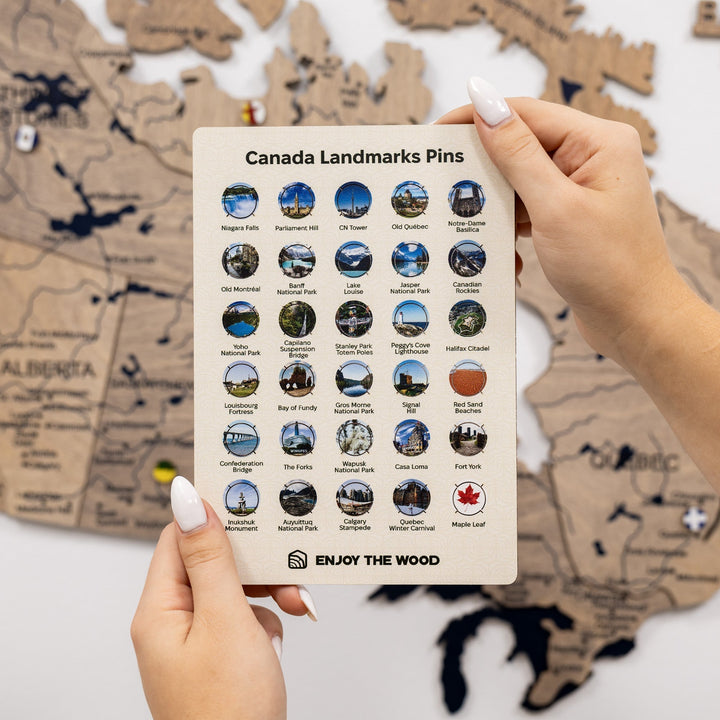 Canada landmarks pin set on display card with multiple round enamel pins, held by hands