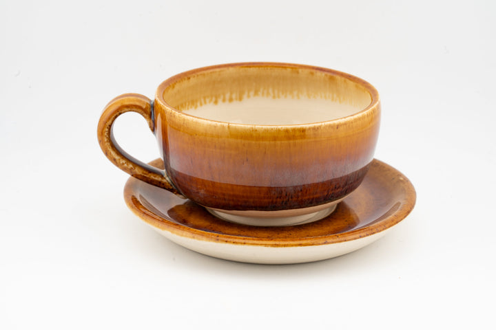 Orange-brown glazed cappuccino cup with loop handle and matching saucer
