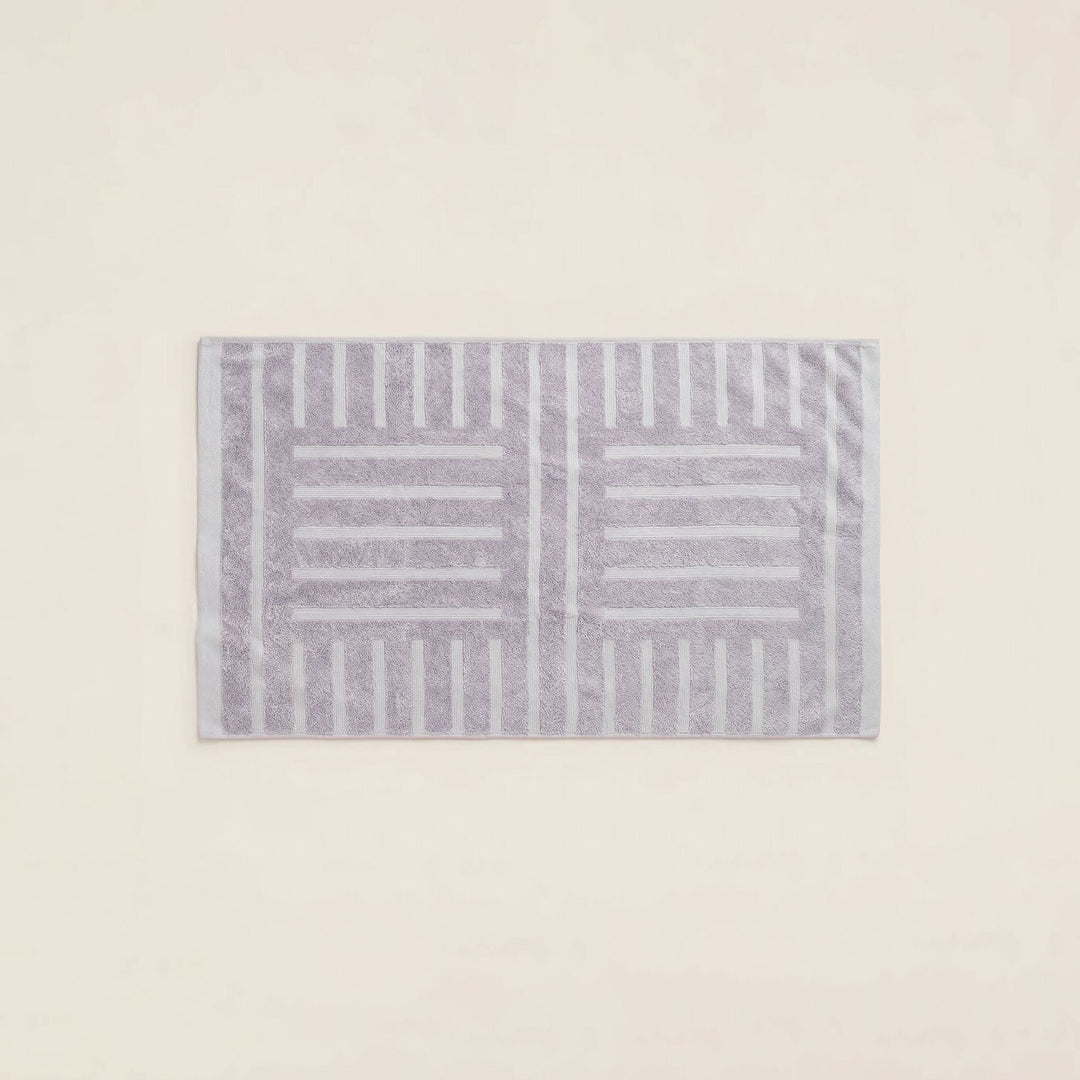 Rectangular striped cotton towel in lilac and light gray, neatly folded