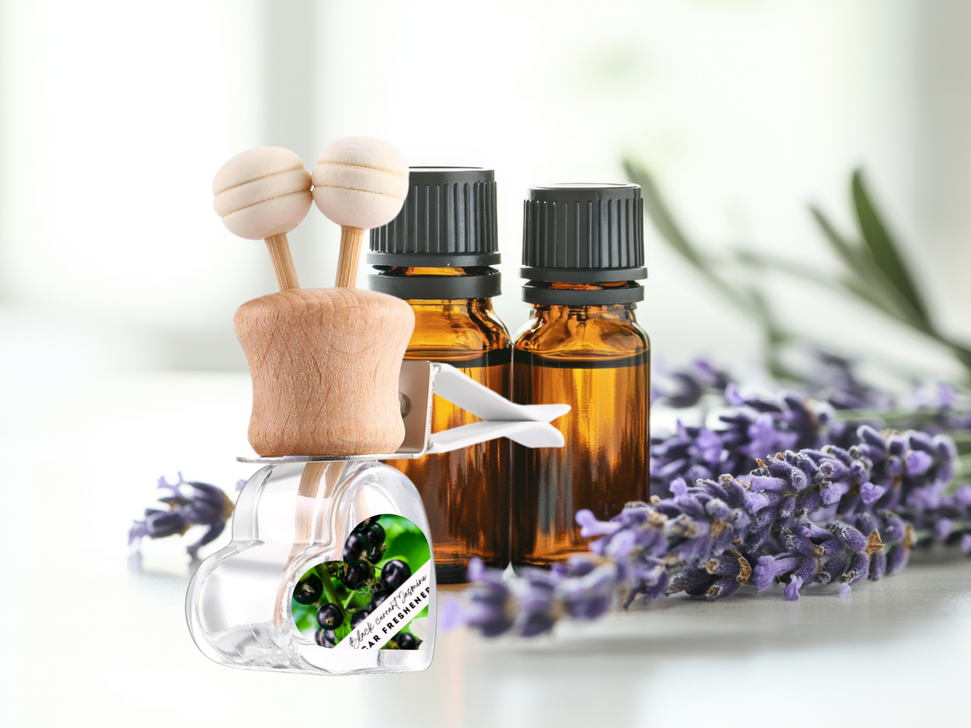 Car vent diffuser glass bottle with wooden holder beside two amber scent bottles