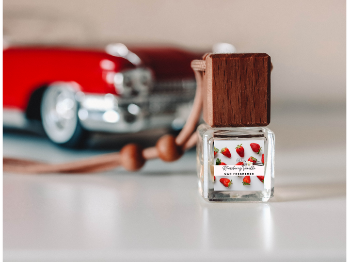Car freshener bottle with dark red liquid inside clear glass on car dashboard