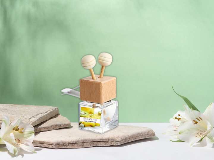 Car air freshener diffuser bottle: clear base with wooden stand and two white caps.