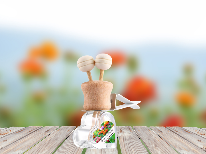 Car vent diffuser with clear bottle, wooden base, two knobs, and hanging scent label
