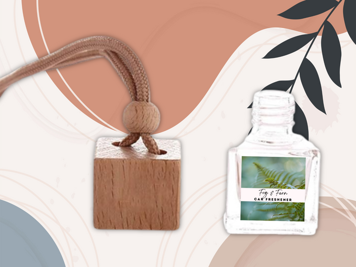 Hanging car freshener pair with square wooden top and clear glass bottle on car dash.