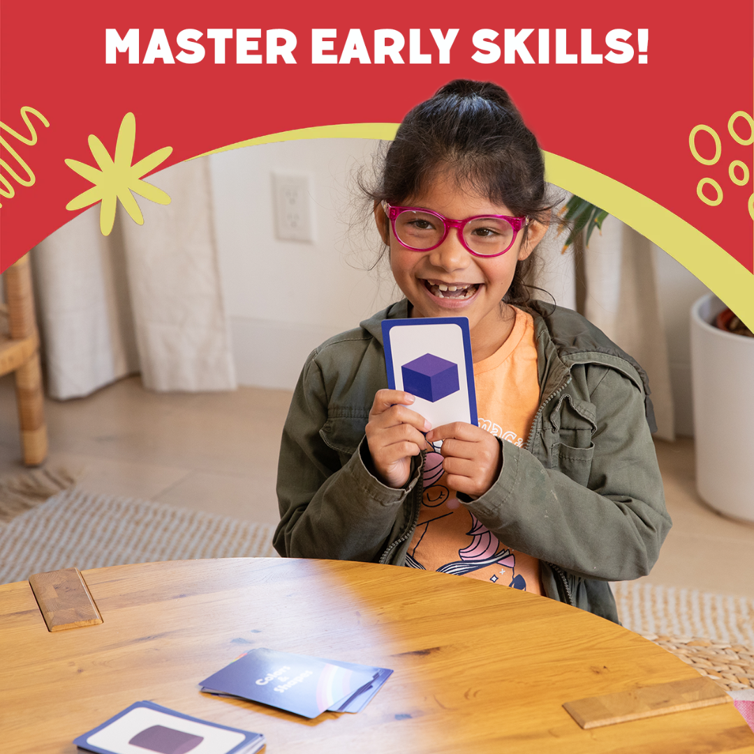 Child holding an educational number card set at a wooden table