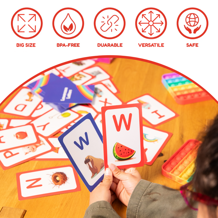 Hand holding colorful letter cards from an educational card set on a table