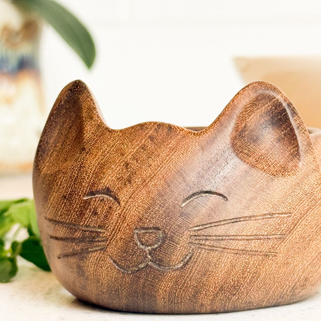 Carved cat-shaped wooden bowl with raised cat ears and face, empty interior