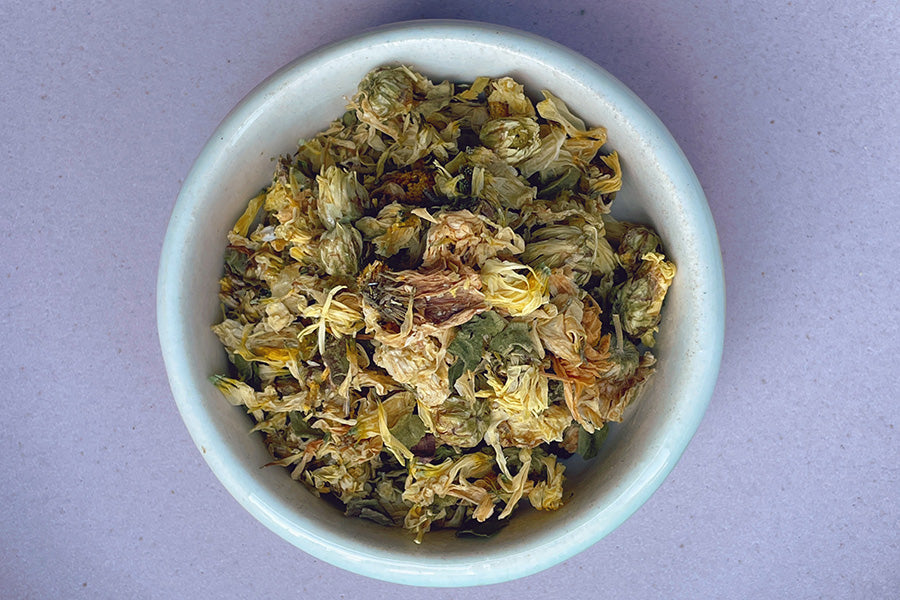 Dried chrysanthemum flower petals in a light blue bowl