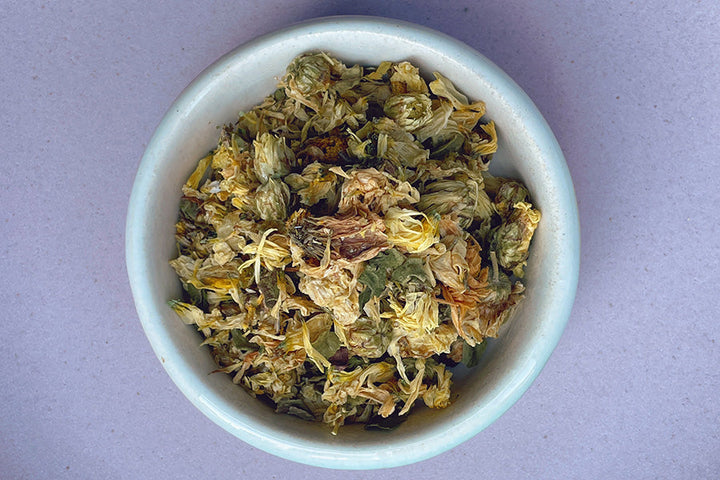 Dried chrysanthemum flower petals in a light blue bowl
