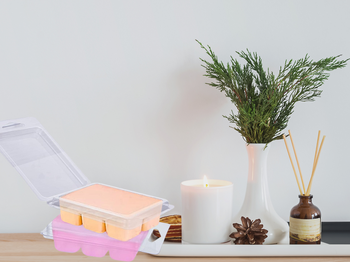 Clear plastic clamshell with peach wax melt cubes and pale pink top cover