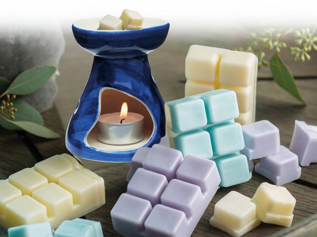 Blue ceramic wax warmer with candle flame and pastel wax melt cubes in trays