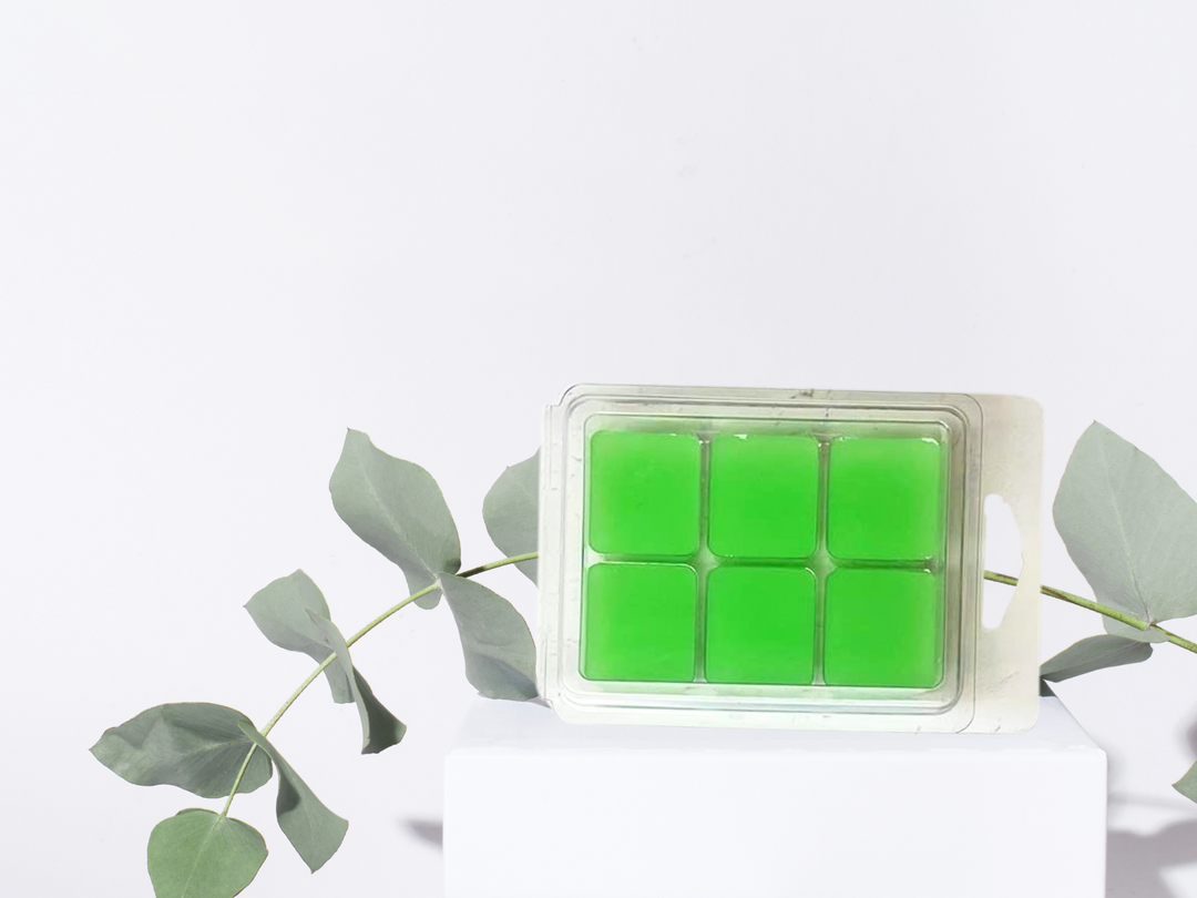 Green wax melt clamshell with bright green cube portions on a white stand