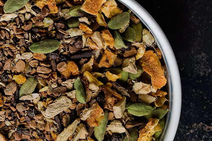 Loose chai tea leaves blend in a white bowl, close-up