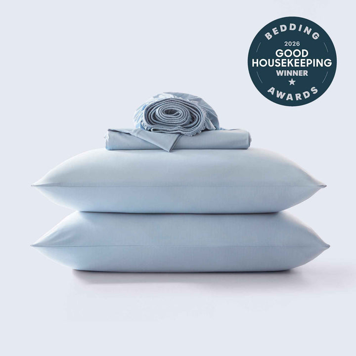 Light blue cooling sheet set with rolled fabric and two stacked pillowcases