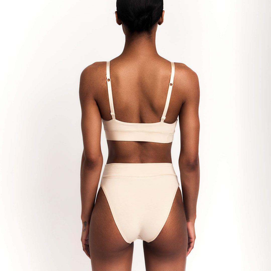 Cheeky tanga briefs in nude/latte, low-rise with minimal back coverage.