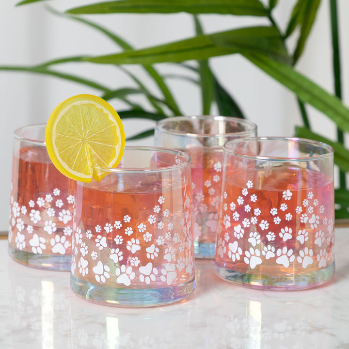 Iridescent glass candle holders with white paw-print decals, orange wax, lemon slice