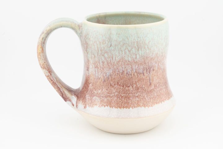 Tall ceramic mug with speckled rose-brown glaze and curved handle, cream base