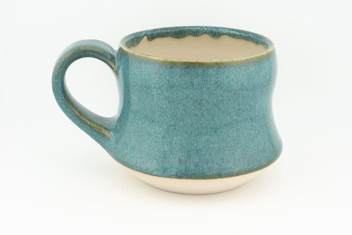 Turquoise ceramic mug with wide handle and speckled glaze, cream interior rim