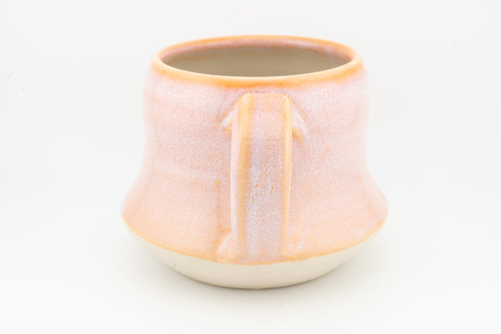 Peach-orange ceramic mug with wide pour spout, vertical glaze panel and cream base