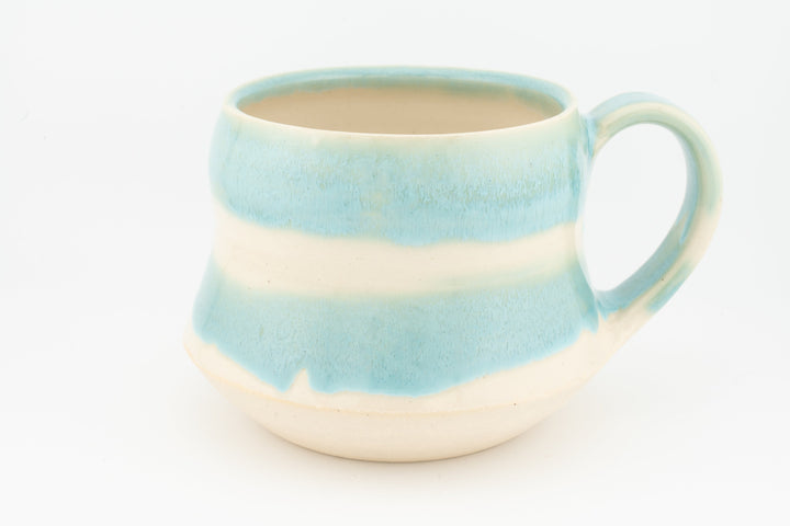 Light blue ceramic mug with wide handle, layered glaze stripe and cream base