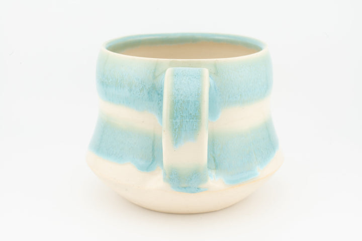 Light blue ceramic mug with drip-pattern glaze and rectangular pour panel, cream base
