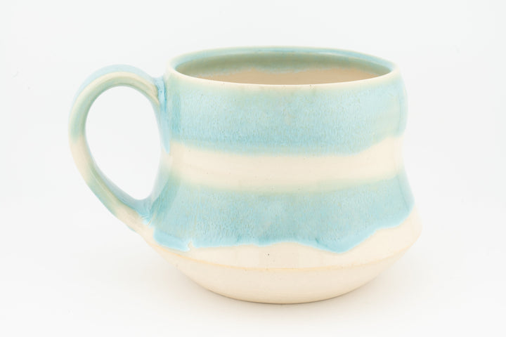 Light blue ceramic mug with wide handle, horizontal stripe glaze and cream base