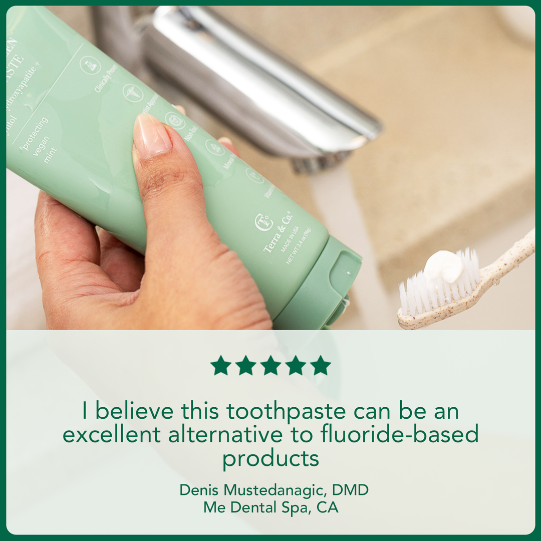 Hand squeezing Gentle Green hydroxyapatite toothpaste onto toothbrush