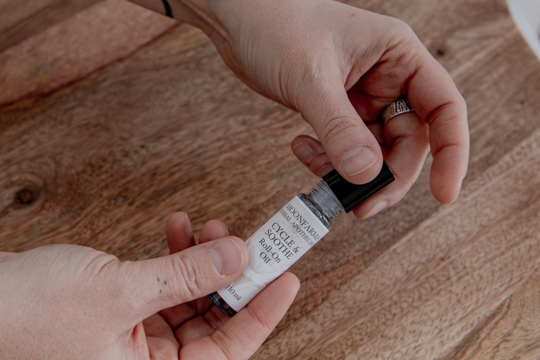 Roll-on oil bottle with black roller cap, held in hands
