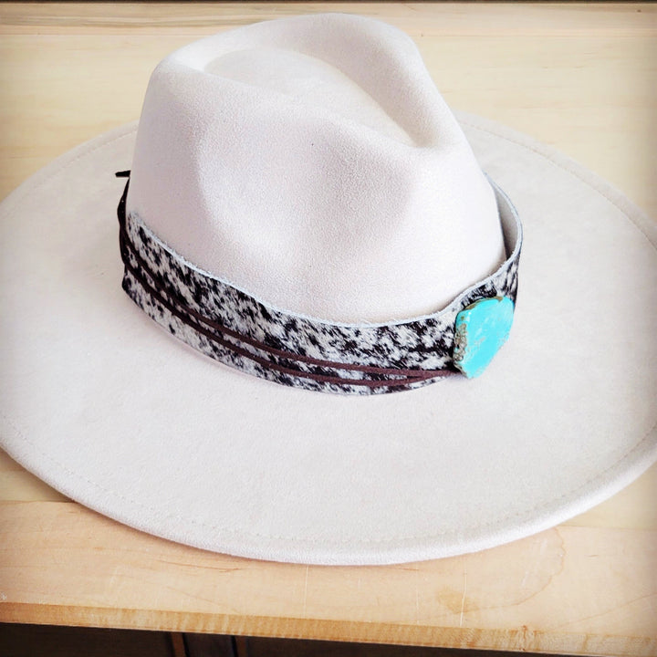 Side view wide-brim white hat with black spotted leather band and turquoise heart buckle