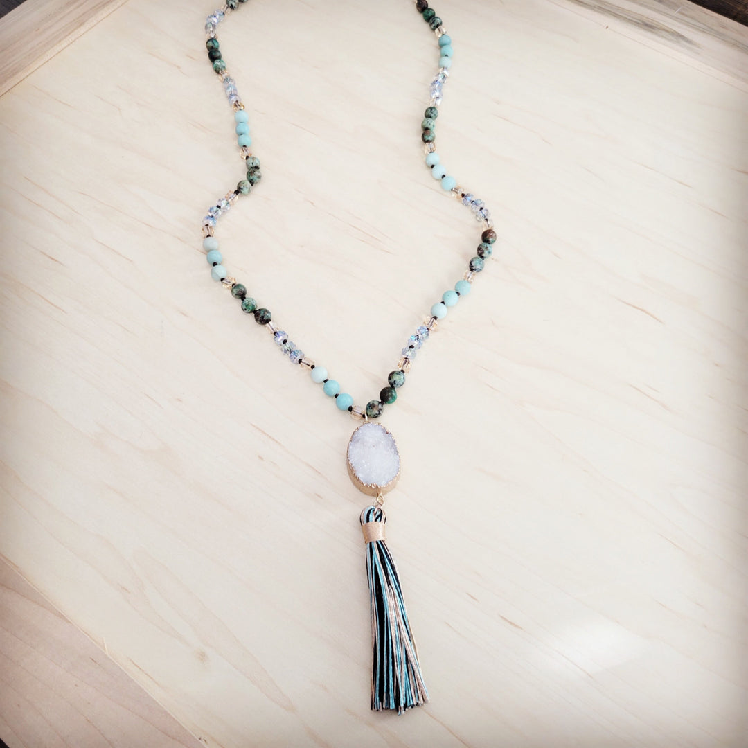 Long beaded necklace with oval druzy pendant and tassel charm in blue tones