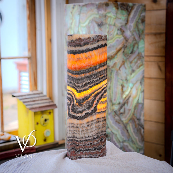 Close view of tall table lamp with cylindrical shade and wavy multicolor striped pattern