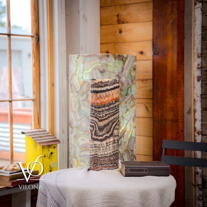 Tall table lamp with speckled ceramic base and cylindrical shade featuring wavy striped pattern