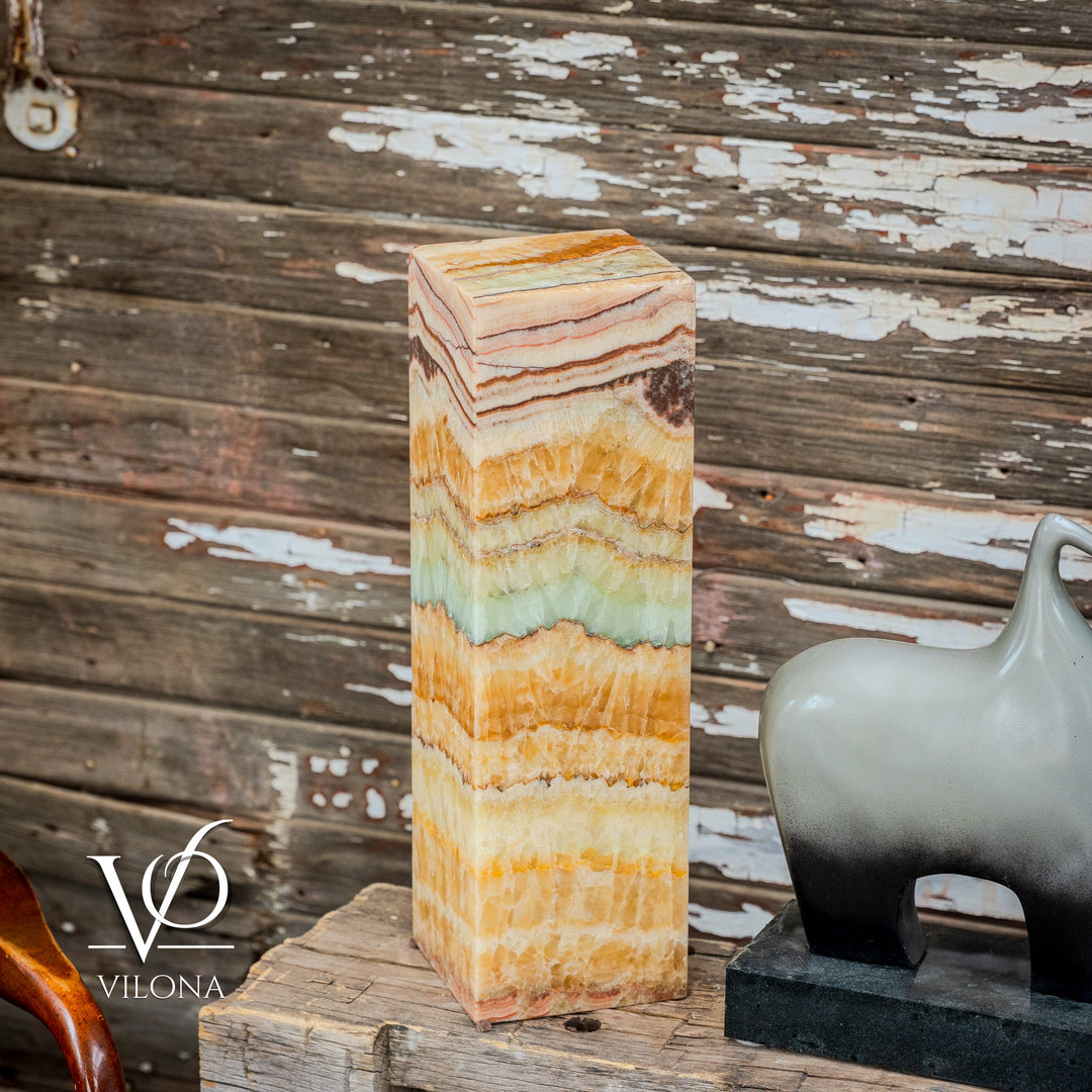 Angled view of square onyx table lamp showing faceted sides in amber, cream, and aqua