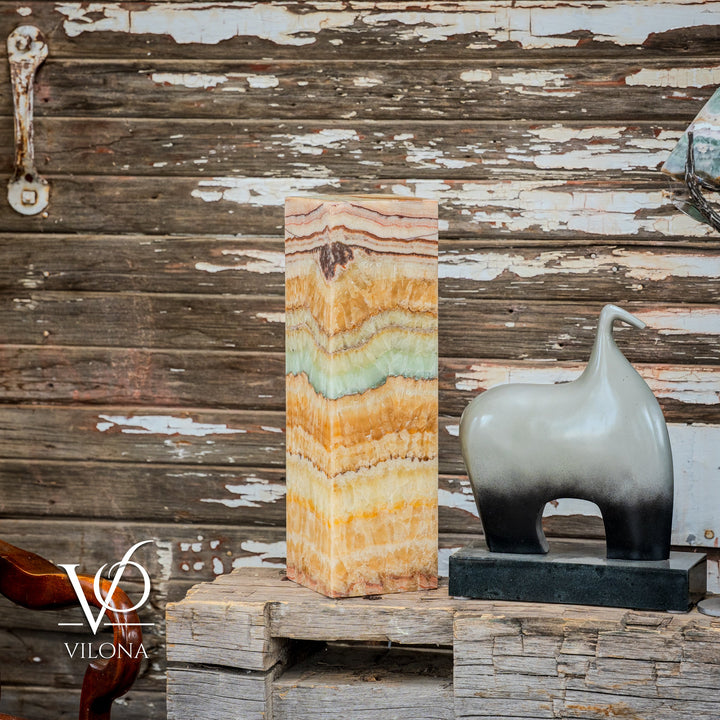Square onyx table lamp on side table, tall faceted stone in gold, cream, and pale aqua