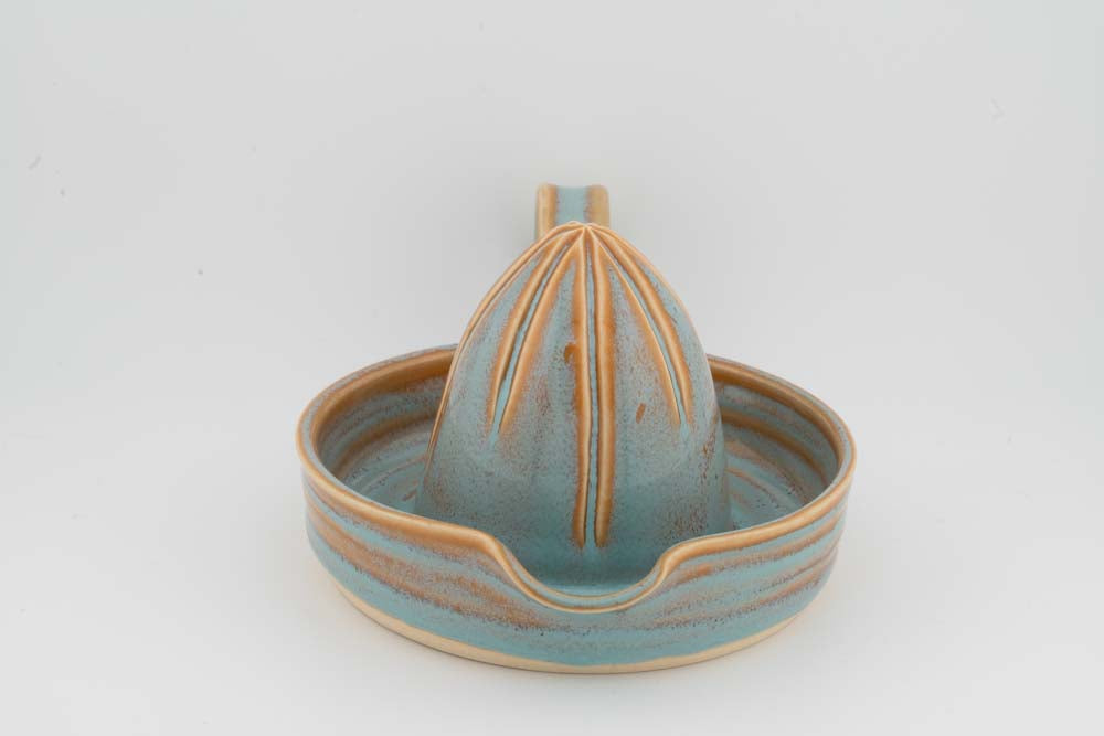 Ceramic citrus juicer with turquoise tray glaze and a raised orange cone center.