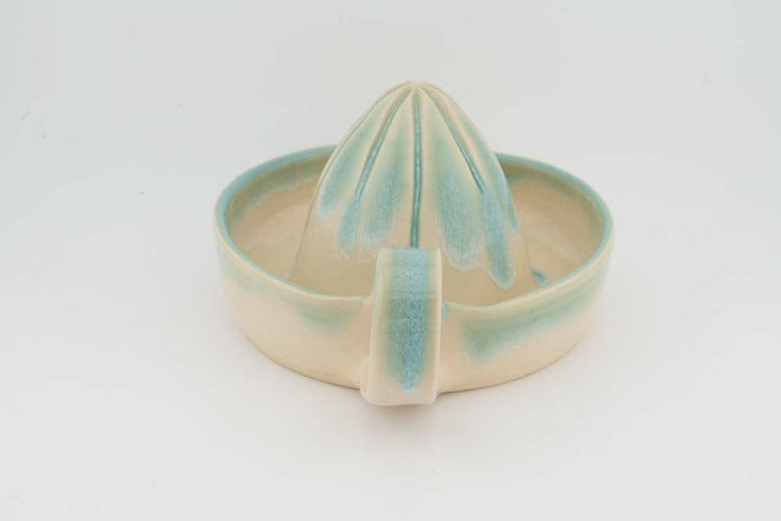 Ceramic citrus juicer with teal cone squeezer and front-facing spout