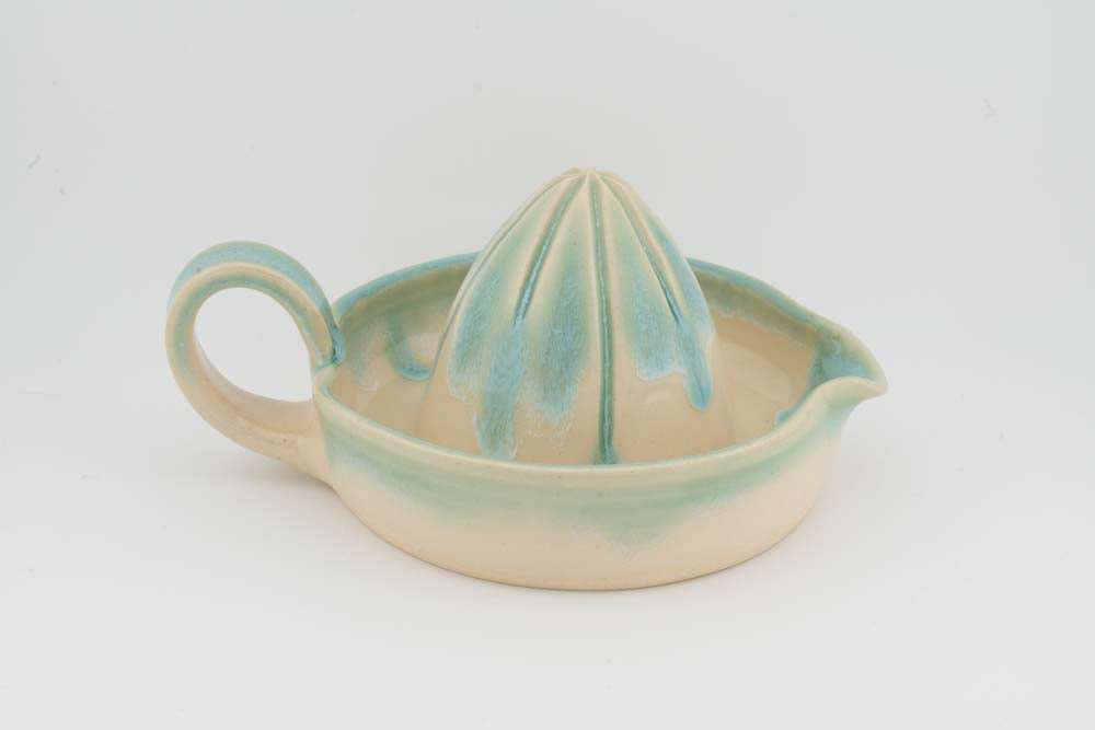 Ceramic citrus juicer with teal cone squeezer and curved side handle