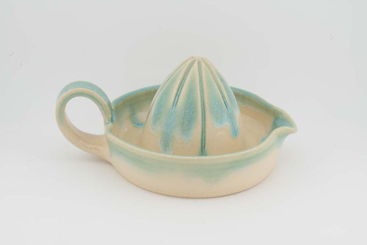 Ceramic citrus juicer with teal cone squeezer and curved side handle