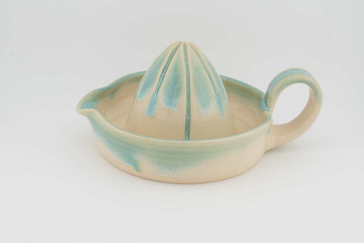Ceramic citrus juicer with teal glaze cone and side spout handle
