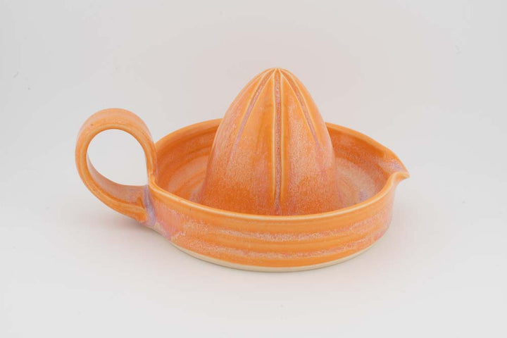 Ceramic citrus juicer with orange glaze cone squeezer and left side handle