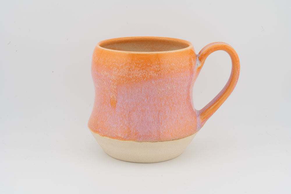 Orange textured tall ceramic mug with curved handle and rounded base