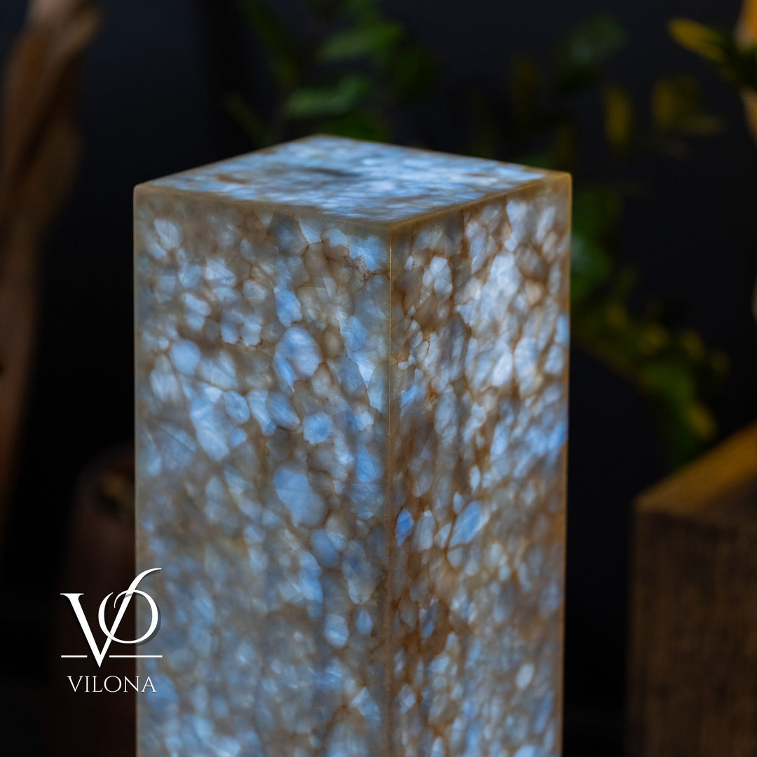 Blue square column floor lamp close-up, glowing textured sides and top.