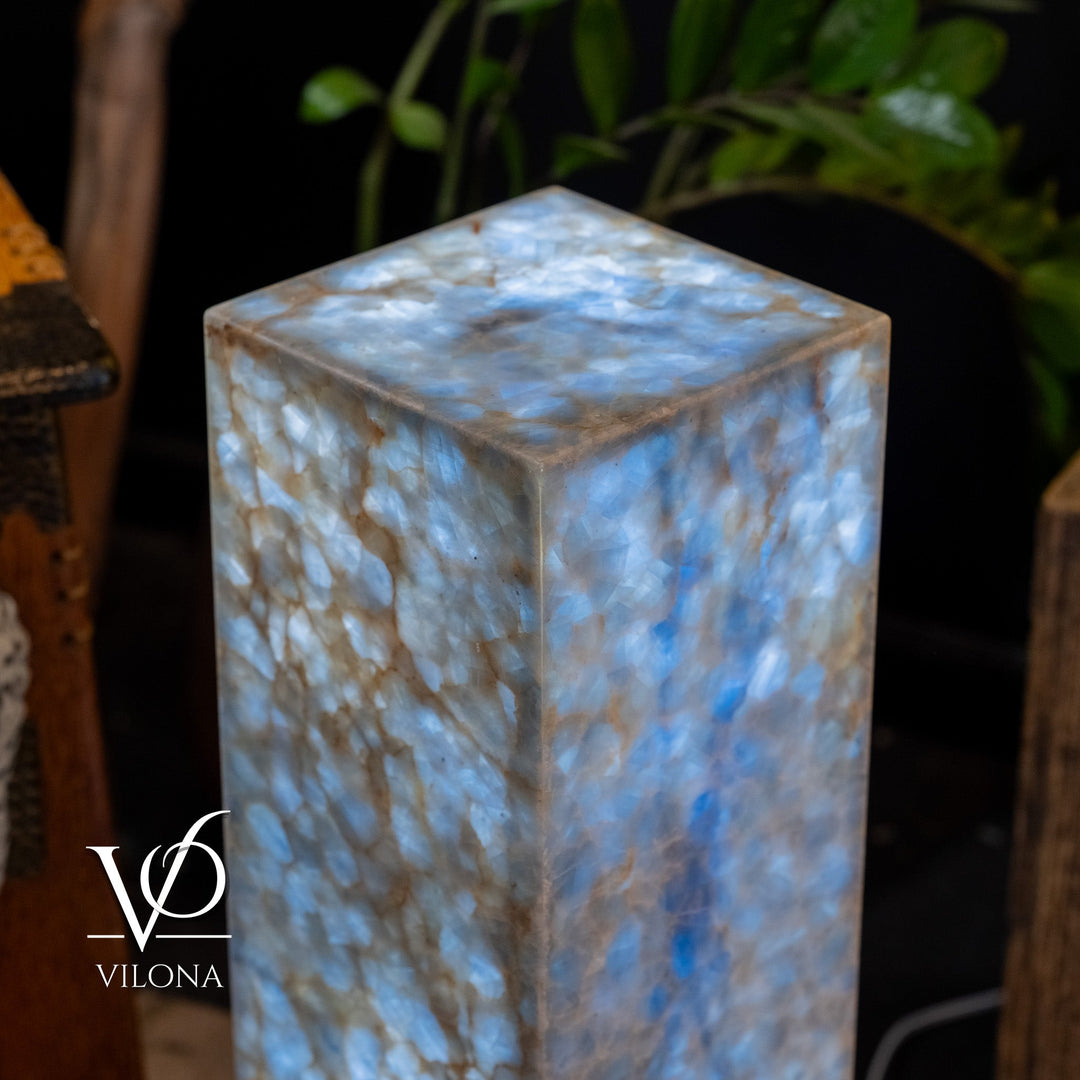 Small square blue stone floor lamp, close-up view of glowing top and textured sides