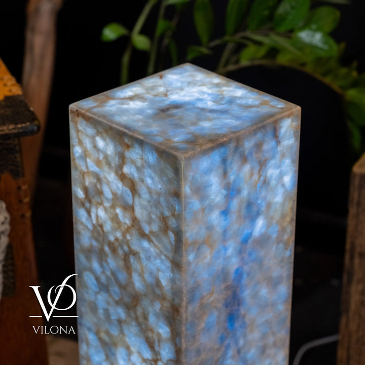 Small square blue stone floor lamp, close-up view of glowing top and textured sides