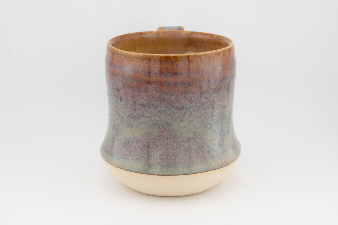 Tall ceramic mug with mottled gray-brown glaze and cream base