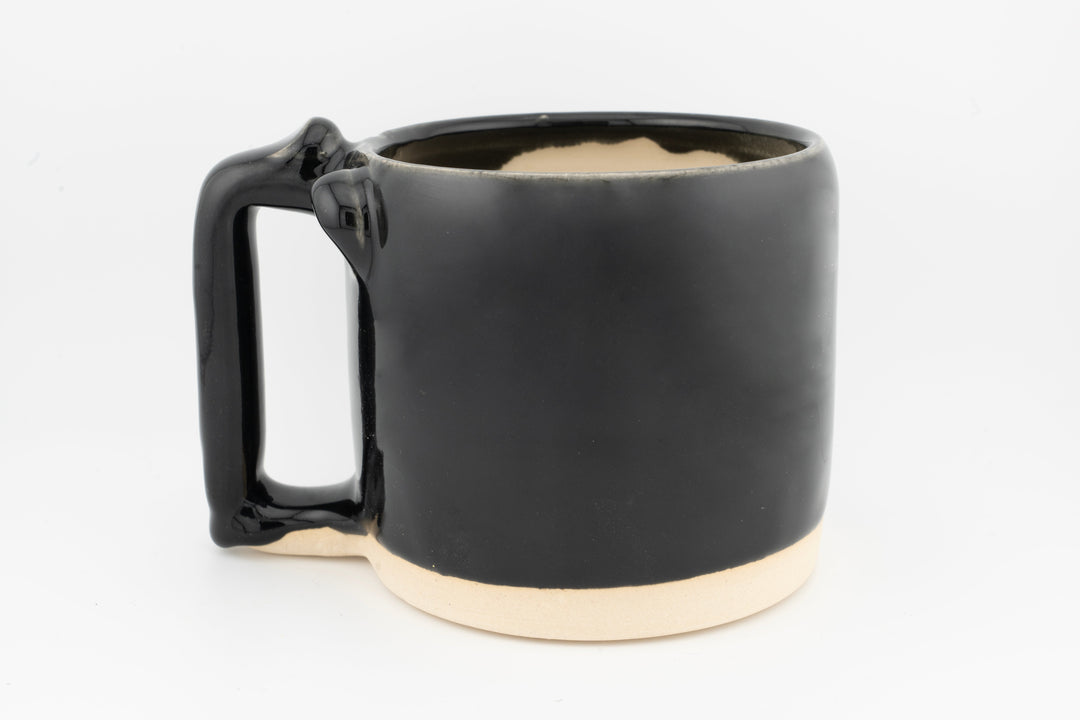 Ceramic mug with glossy black glaze, curved side handle, and drip accents