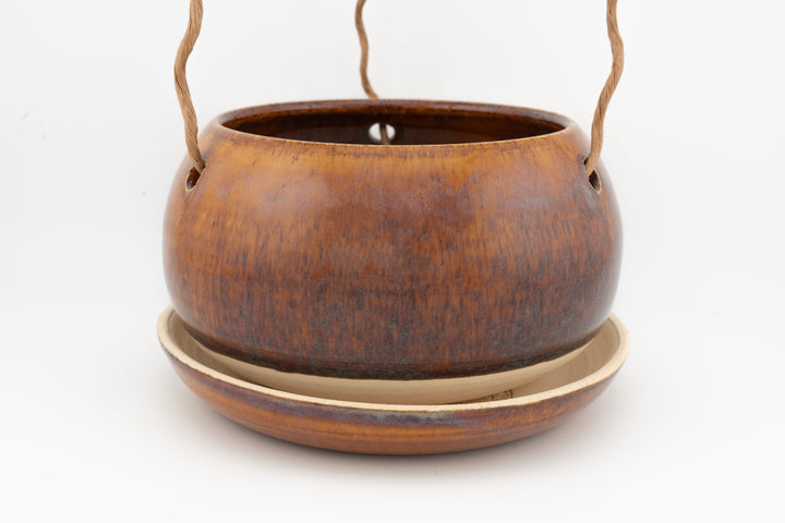 Glazed hanging planter with rope handles and round saucer base, warm brown